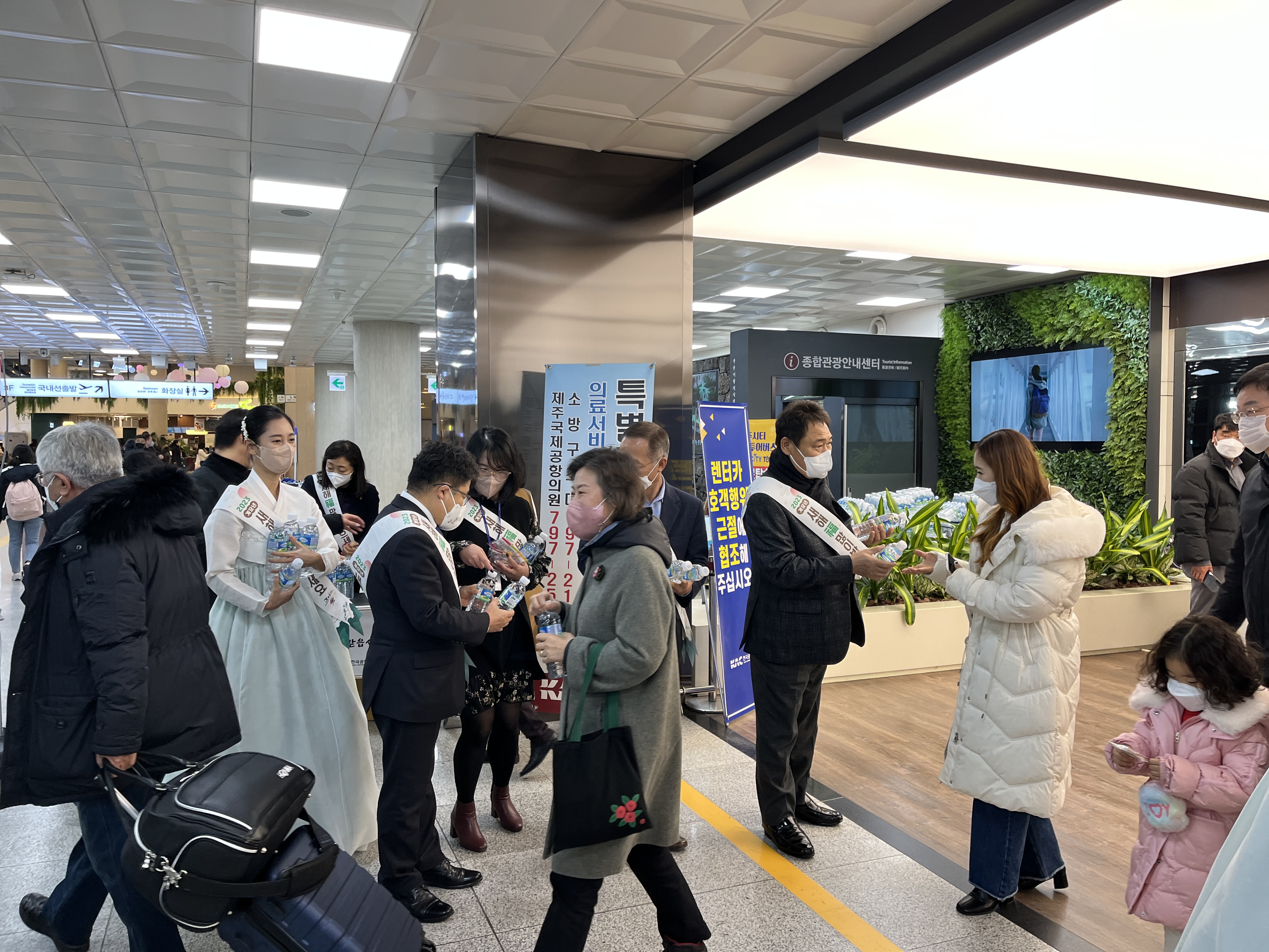 변덕승 제주도 관광교류국장과 제주도관광협회 부동석회장 등이 20일 제주공항 도착장에서 귀성객들을 환영하며 삼다수와 제주관광기념품을 나눠주고 있다. 제주도관광협회 제공