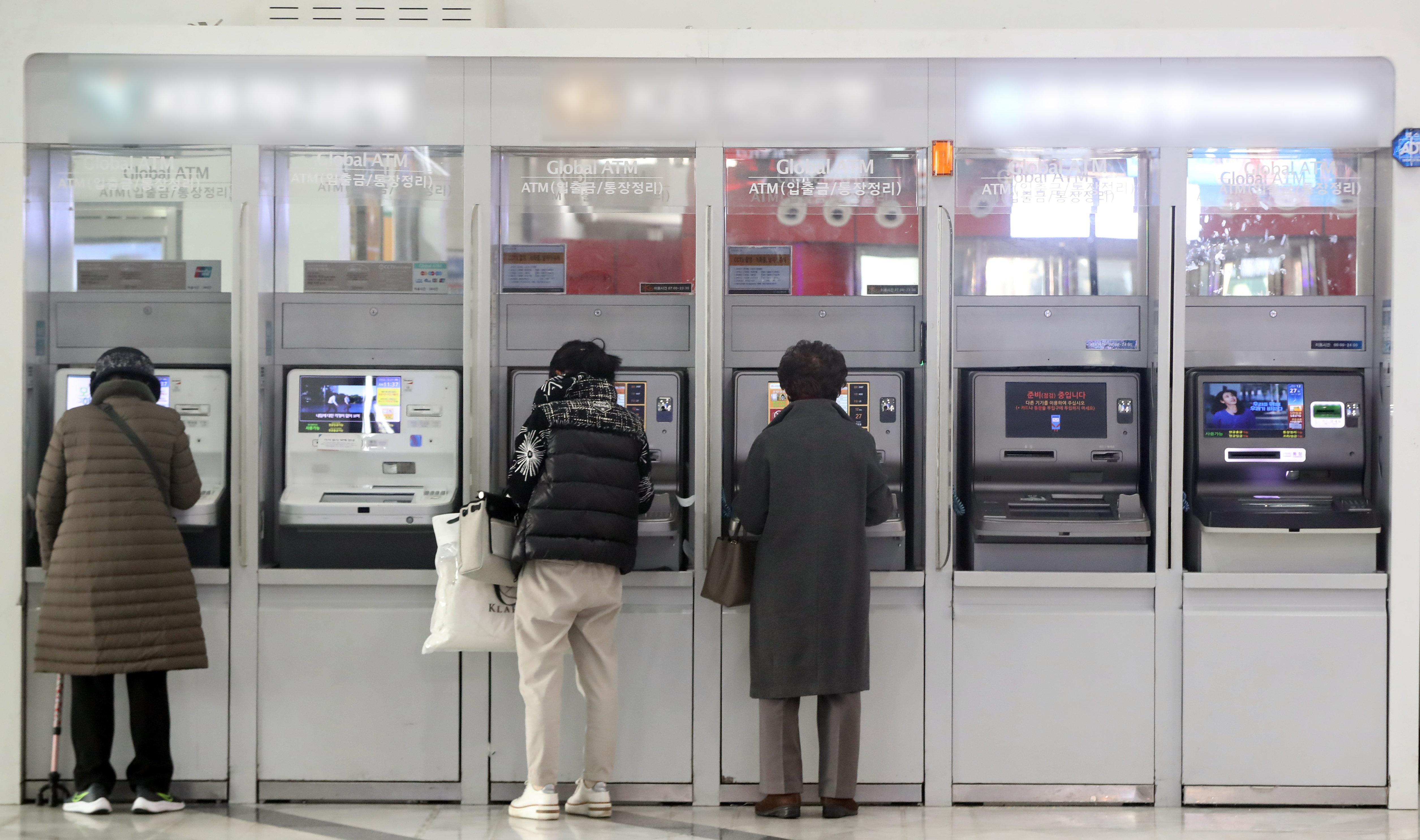 27일 서울 시내 한 건물에 설치된 은행의 현금인출기(ATM)에서 시민들이 입출금을 하는 모습. 2022.12.27 뉴스1