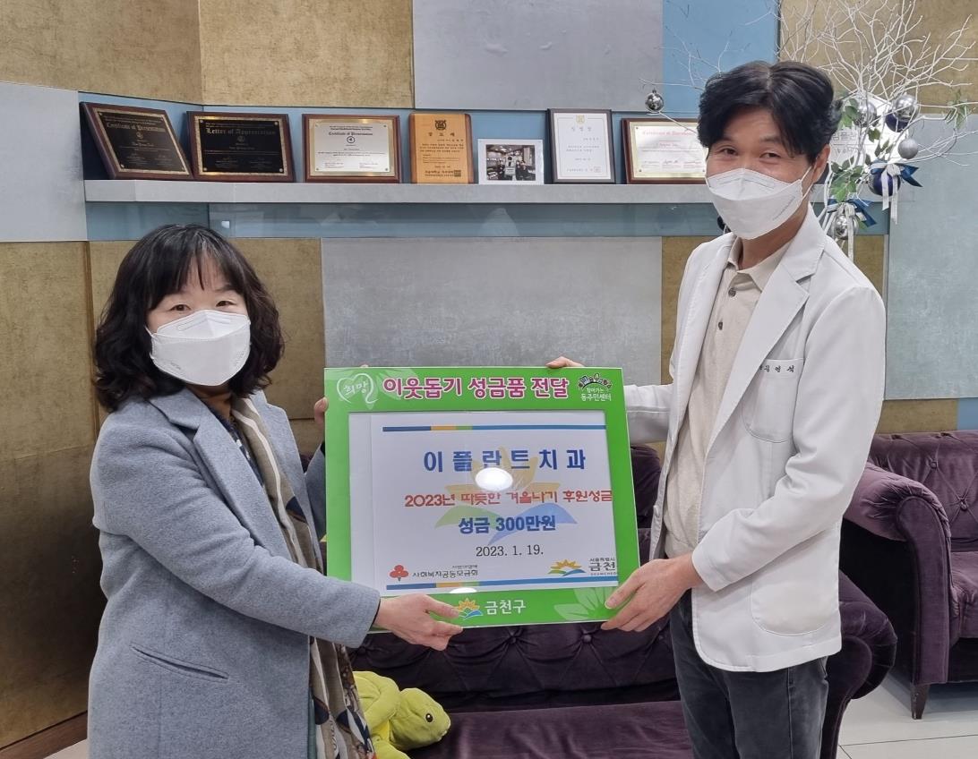 지난 19일 김영석(오른쪽) 독산동 이플란트치과의원 원장이 독산1동 주민센터에 성금 300만원을 기탁하고 있다. 금천구 제공