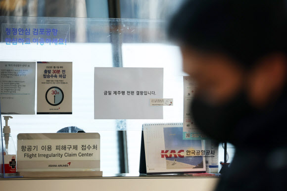 설 연휴 마지막 날인 24일 오전 제주에 급변풍 특보와 강풍 특보가 발효된 가운데 김포공항 내 아시아나 항공기 이용 피해구제 접수처에 ‘금일 제주행 전편 결항’ 안내문이 붙어있다. 2023.1.24 연합뉴스