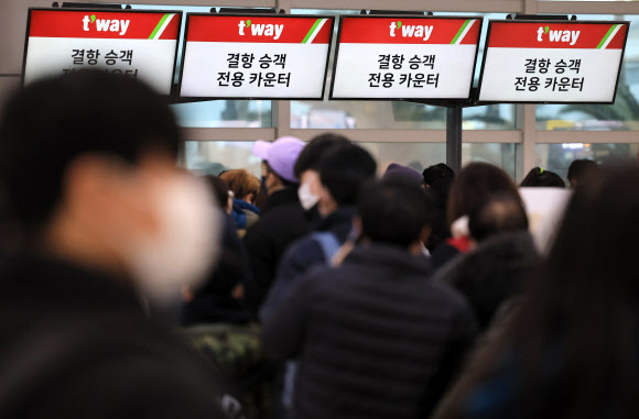 설 연휴 마지막 날인 24일 오전 폭설과 강풍이 몰아쳐 항공편이 전편 결항한 가운데 승객들이 대기표를 구하기 위해 각 항공사 대기전용 카운터에 길게 줄을 서 있다. 2023.1.24 연합뉴스