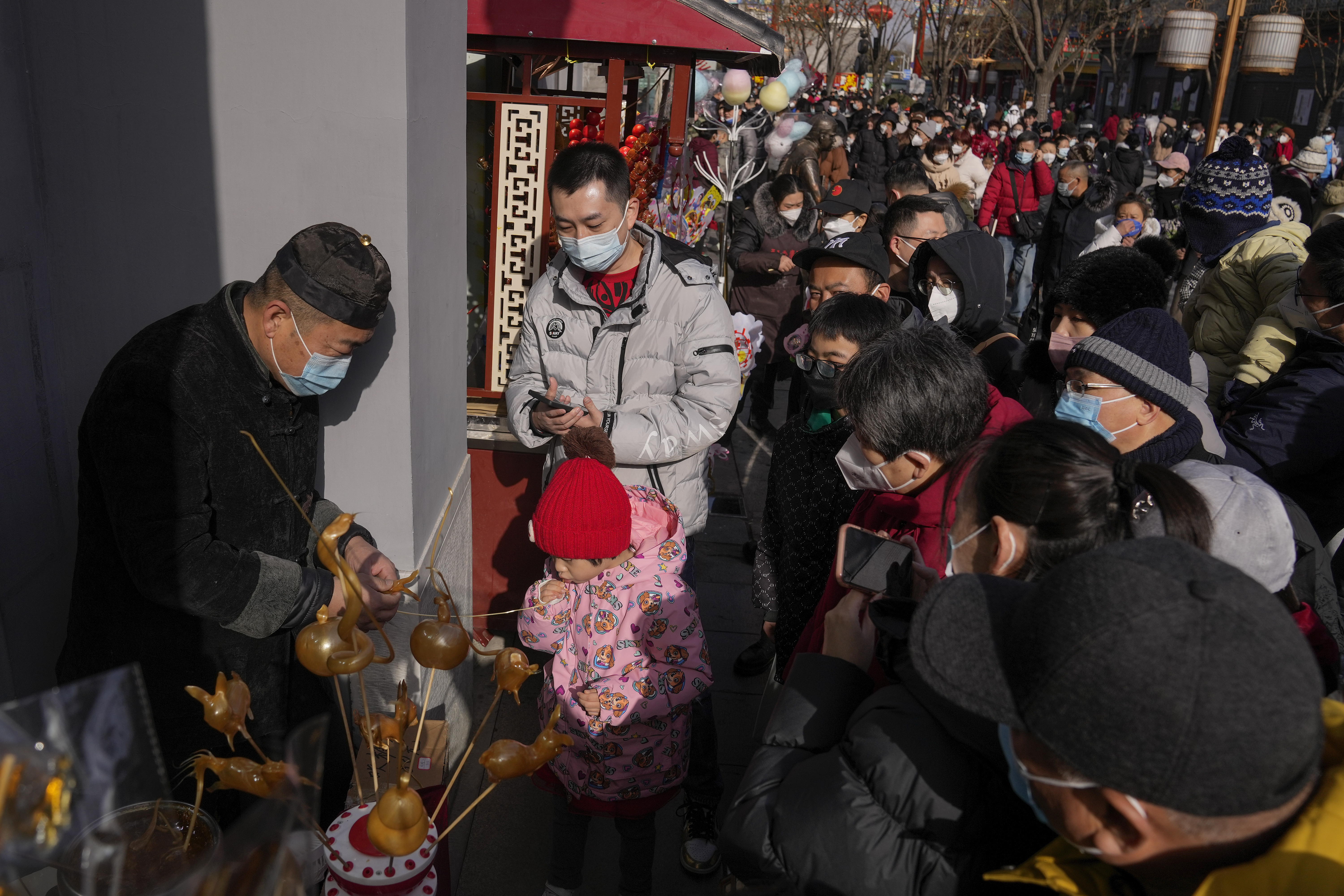 중국 베이징 시내 거리가 22일 춘절을 맞이한 인파로 가득찬 가운데 사람들이 노점 앞에 모여있다. 베이징 AP 연합뉴스