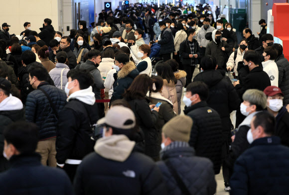 설 연휴 마지막 날인 24일 오전 폭설과 강풍이 몰아쳐 항공편이 전편 결항한 가운데 승객들이 대기표를 구하기 위해 각 항공사 대기전용 카운터에 길게 줄을 서 있다. 2023.1.24 연합뉴스