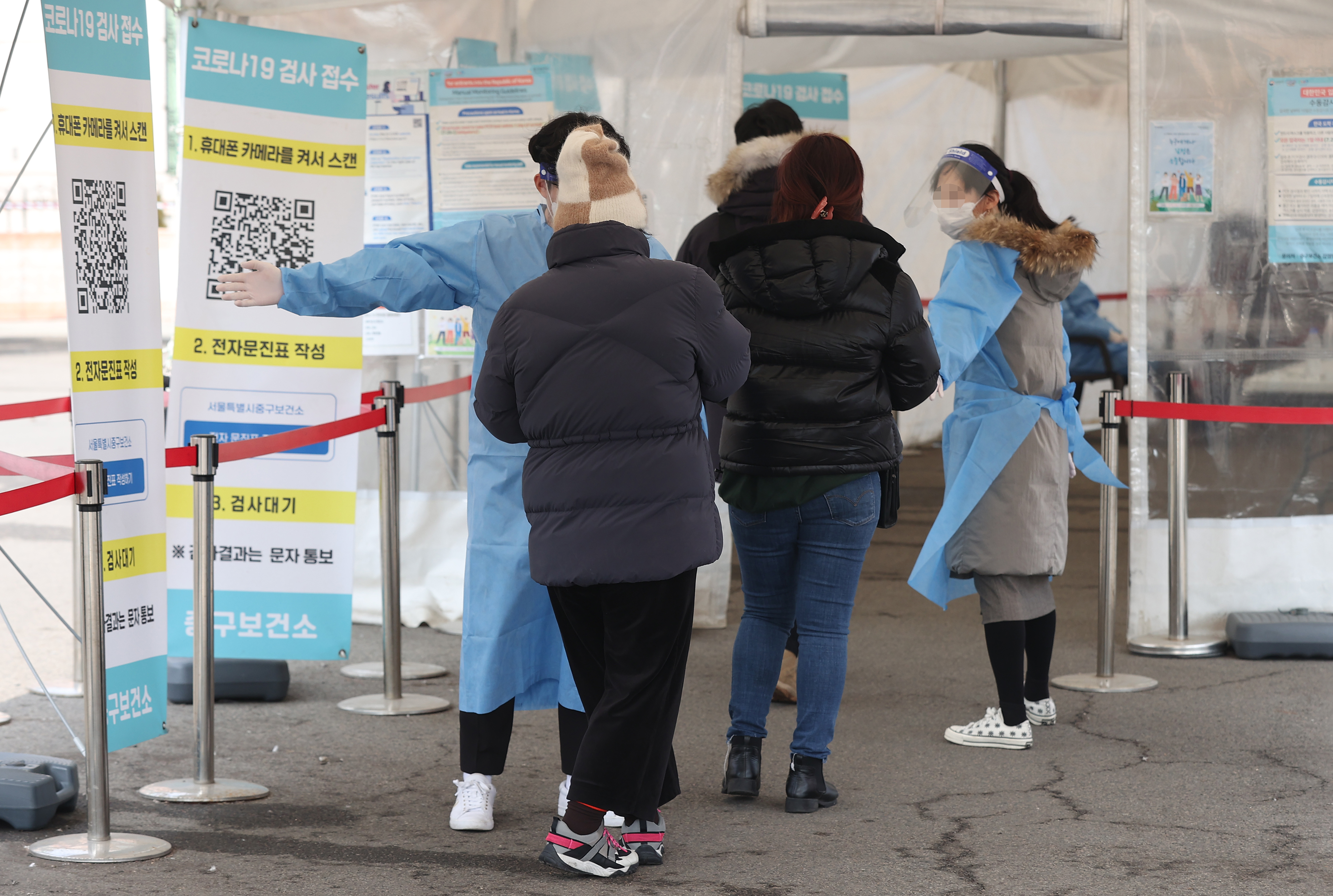 서울역광장에 마련된 임시선별검사소를 찾은 시민들이 의료진 안내를 받고 있다.  연합뉴스