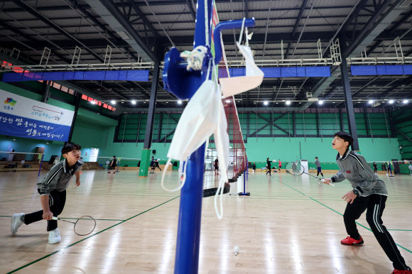 실내마스크 착용 의무 해제 첫날인 30일 오전 서울의 한 스포츠센터에서 학생들이 마스크를 벗어두고 배드민턴을 치고 있다. 2023.1.30 연합뉴스