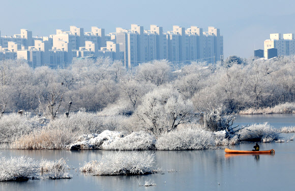 30일 강원 춘천시 소양강에 핀 상고대 사이로 한 시민이 카누를 타고 있다. 2023.1.30 연합뉴스