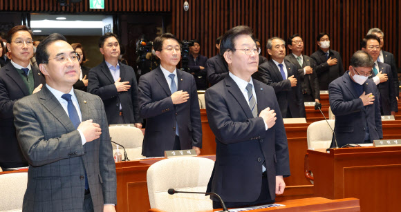 더불어민주당 이재명 대표와 박홍근 원내대표, 의원들이 30일 국회에서 열린 의원총회에서 국민의례를 하고 있다. 연합뉴스
