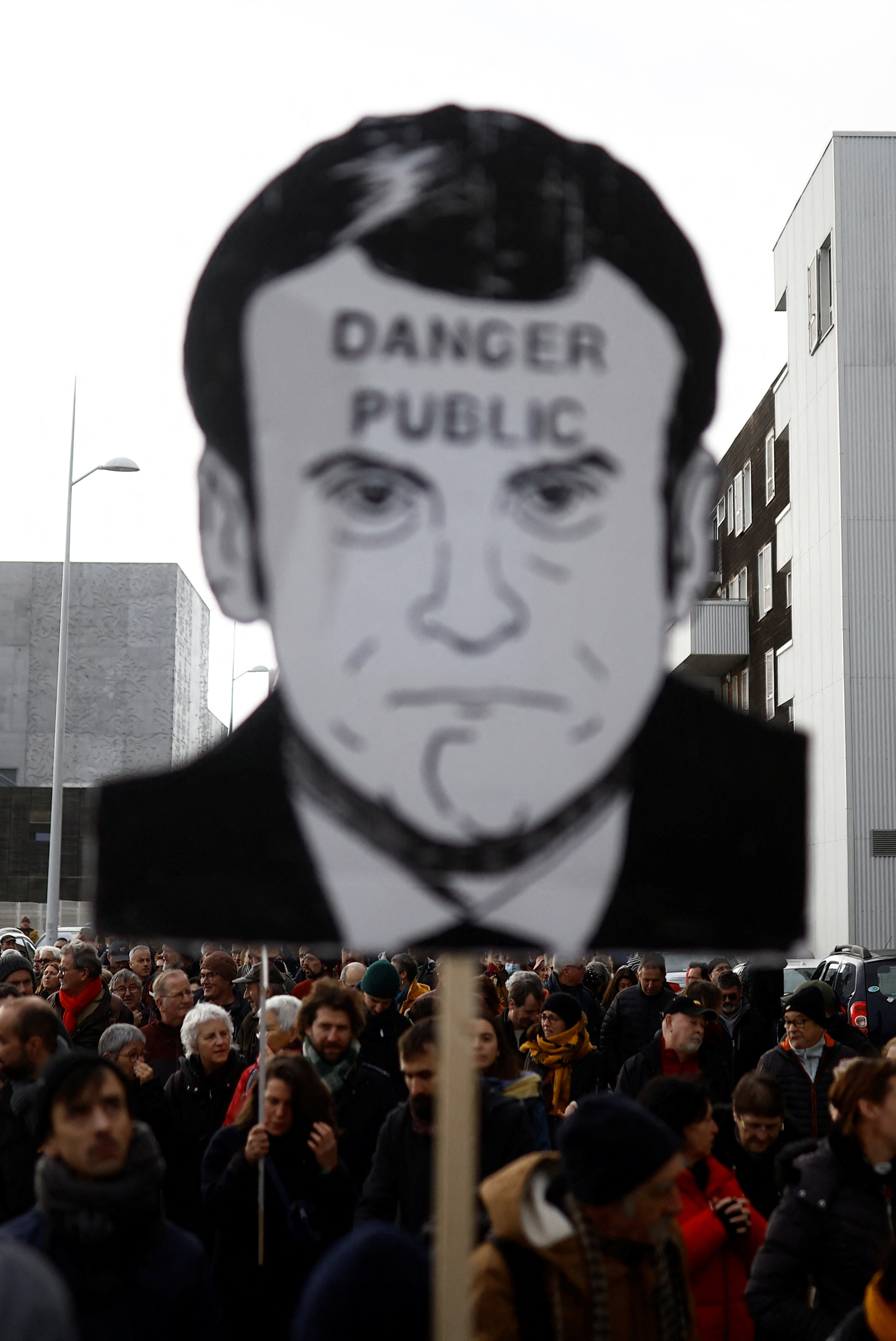 31일(현지시간) 생나제르 지역에서 열린 연금 개혁 반대 시위에서 한 참가자가 에마뉘엘 마크롱 프랑스 대통령의 얼굴에 ‘공공 위험’이라고 적힌 피켓을 들고 있다. 생나제르 로이터 연합뉴스
