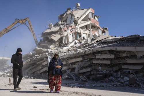 지진으로 무너진 튀르키예 누르다지 지역의 한 건물 앞을 9일 시민들이 지나가고 있다. 누르다지 AP 연합뉴스