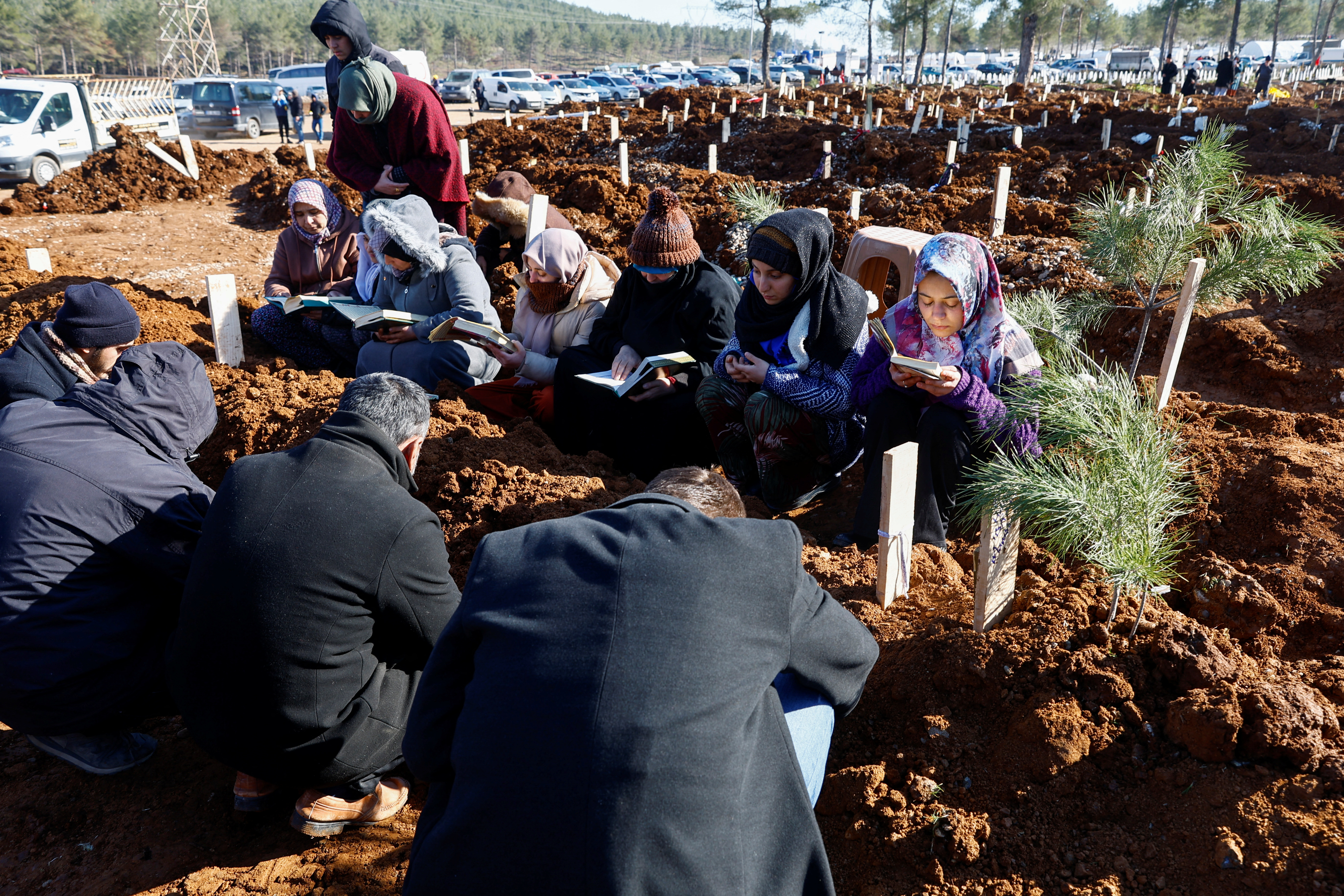 9일(현지시간) 튀르키예(터키) 카라만마라슈의 지진 사망자 집단 매장지에서 사람들이 코란을 편 채 장례를 치르고 있다. 2023.2.9 로이터 연합뉴스