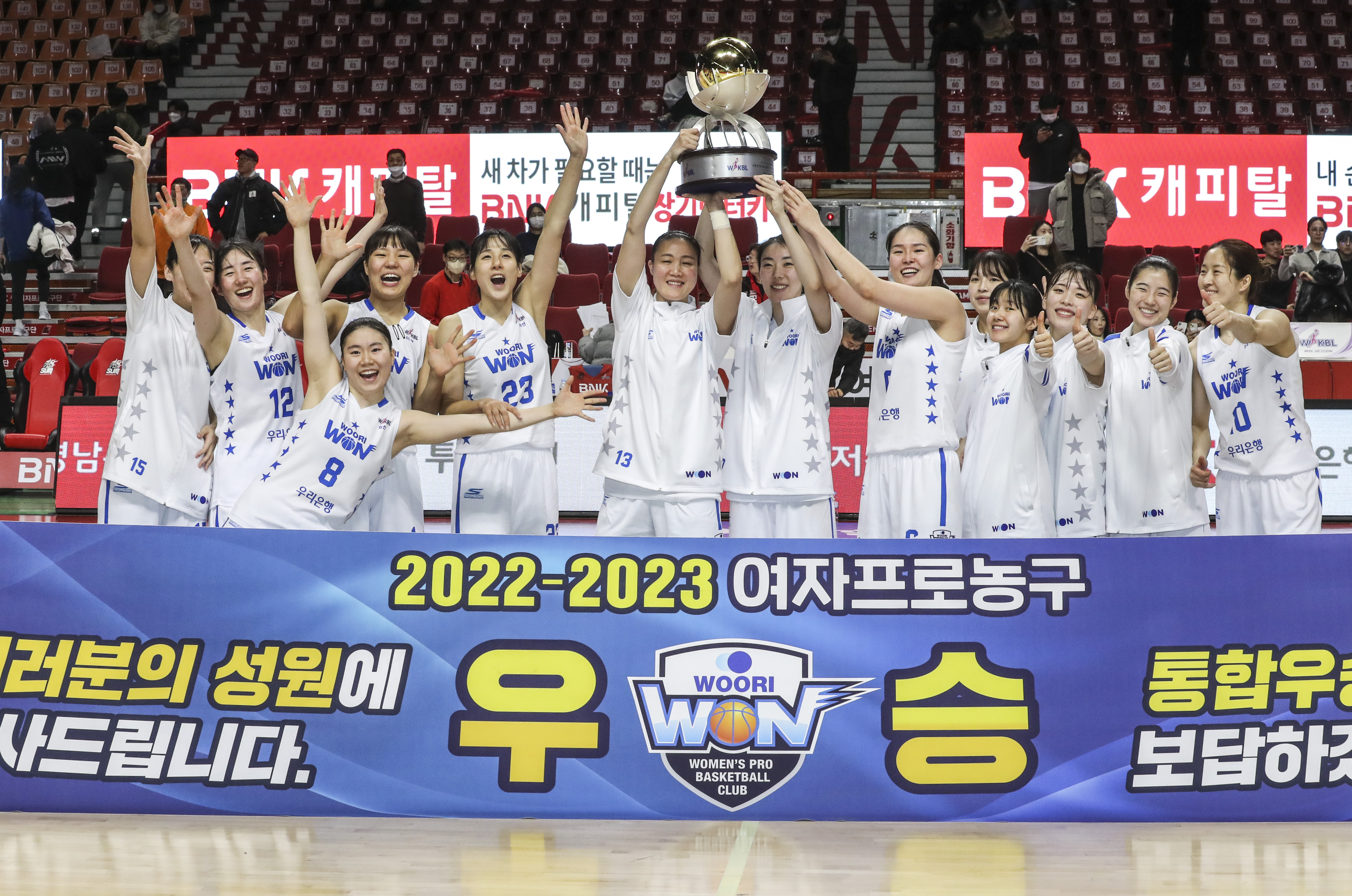 여자프로농구 우리은행 선수들이 13일 부산 사직실내체육관에서 열린 부산 BNK와의 원정 경기에서 승리하며 통산 열네 번째 정규리그 우승을 확정한 뒤 트로피를 들어 올리며 기뻐하고 있다. 부산 연합뉴스