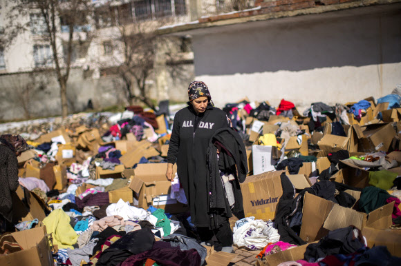 튀르키예 강진에서 살아남은 한 여성이 수도 앙카라 인근에서 기부된 옷을 확인하고 있다. 2023.2.13 AP 연합뉴스