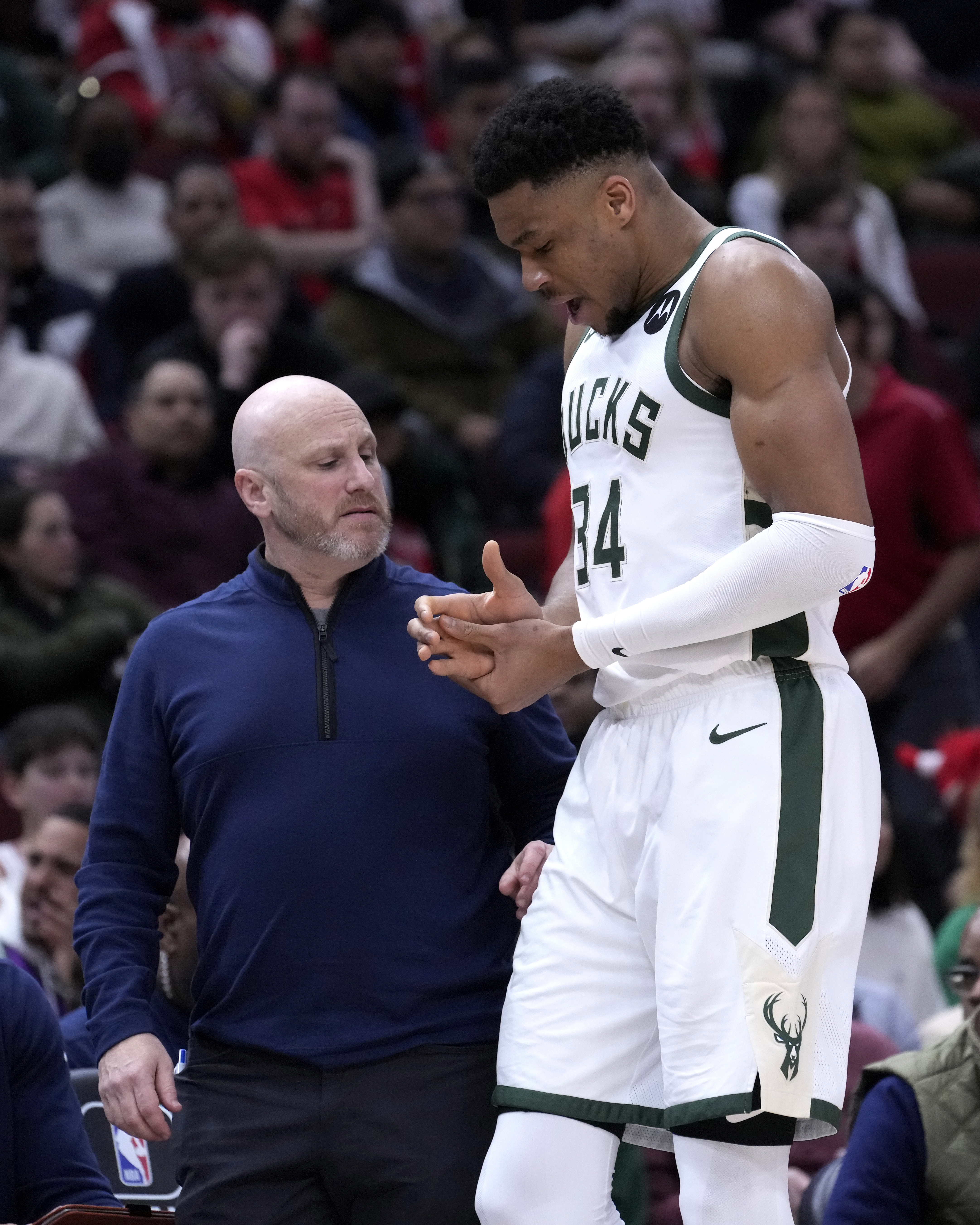 밀워키 벅스의 아테토쿤보가 17일(한국시간) 시카고 불스와의 NBA 경기 도중 오른쪽 팔목을 다친 뒤 의무 요원과 라커룸으로 향하며 팔목을 붙잡고 있다. AP 연합뉴스