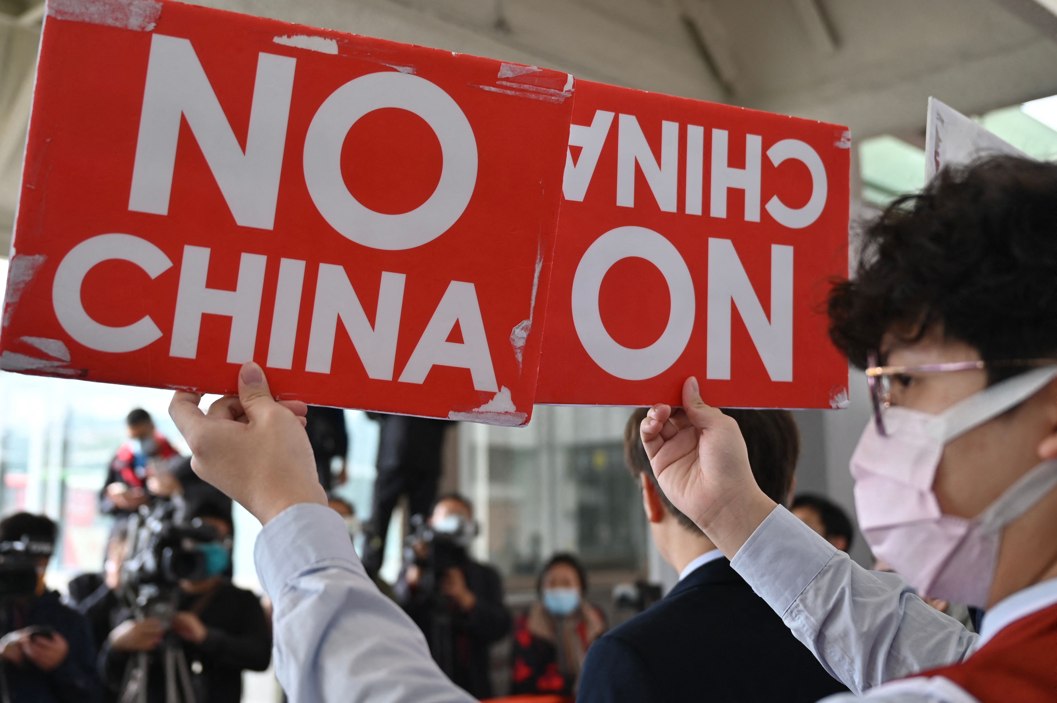 18일(현지시간) 대만에 중국 공무원 대표단이 도착한 가운데 시민운동가가 이에 반대하는 손팻말을 들고 있다. AFP 연합뉴스