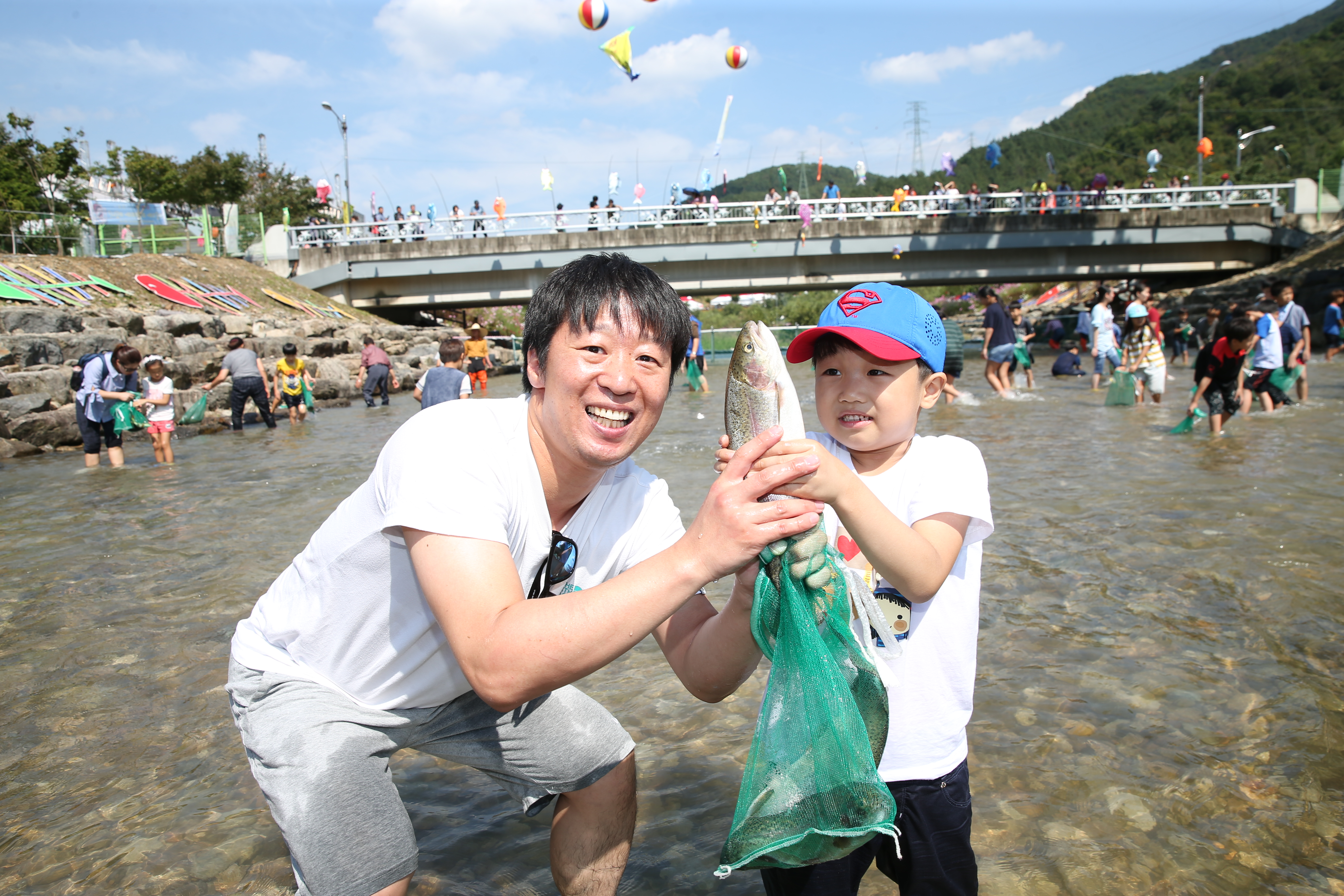 완주군이 개최한 와일드&amp;로컬푸드축제 참가자들이 맨손으로 고기 잡기 체험을 즐기고 있다.