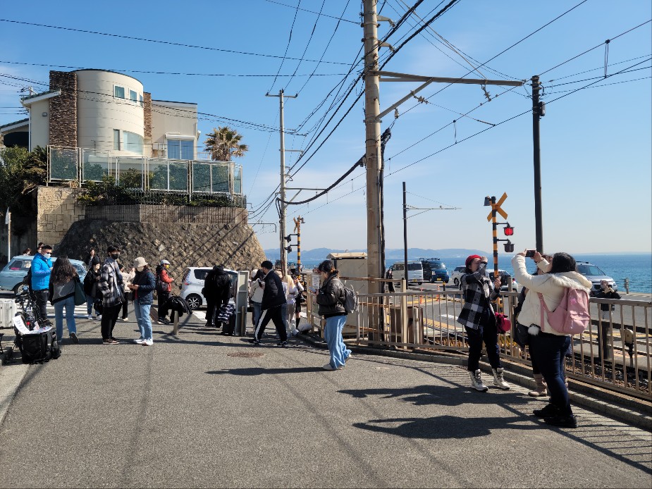 지난 17일 일본 가나가와현 가마쿠라시 가마쿠라 고코마에역 건널목에서 관광객들이 일본 애니메이션 ‘더 퍼스트 슬램덩크’의 배경을 중심으로 기념사진을 찍고 있다.