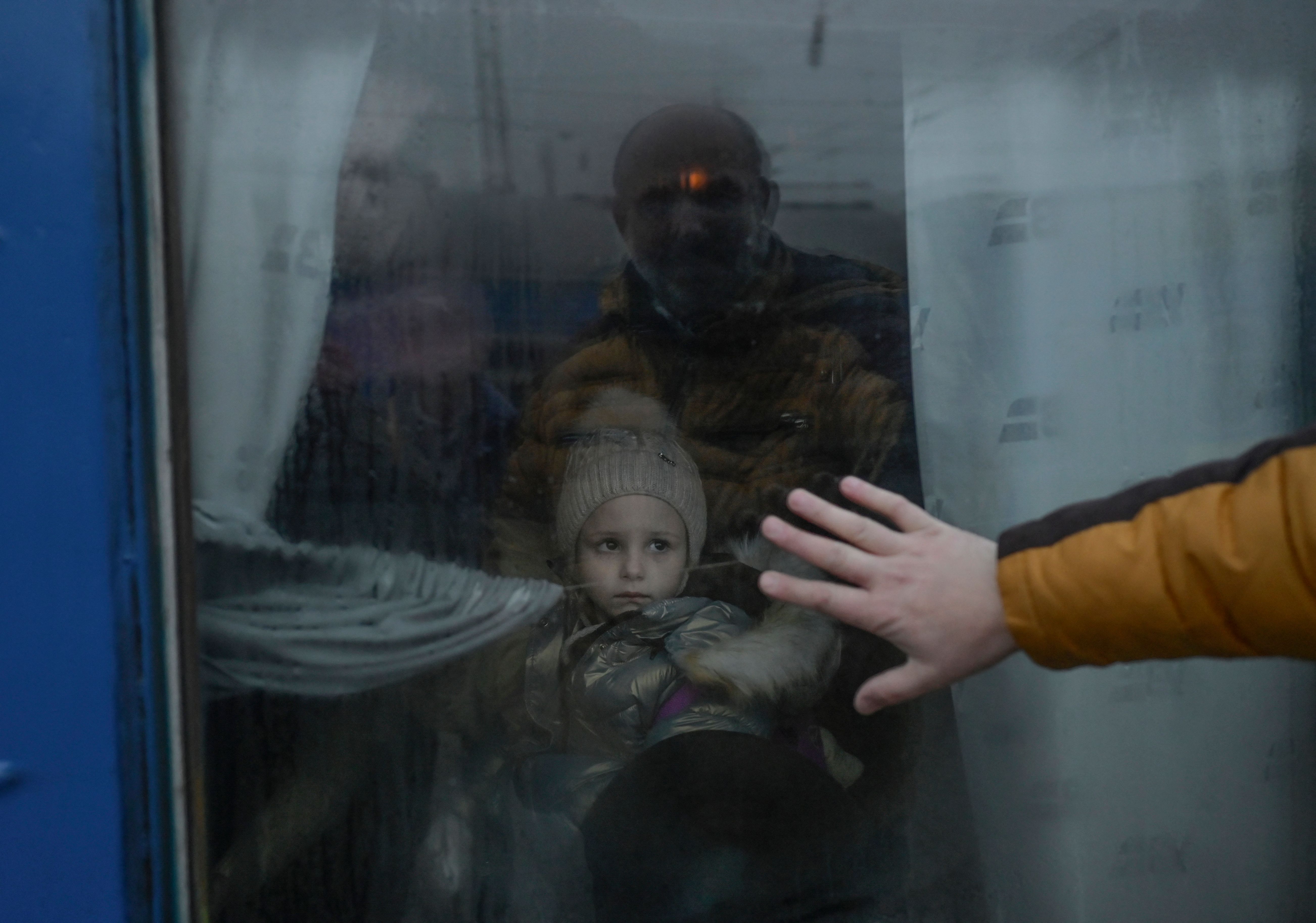 (FILES) In this file photo taken on March 07, 2022 a father puts his hand on the window as he says goodbye to his daughter in front of an evacuation train at the central train station in Odessa. (Photo by BULENT KILIC / AFP)