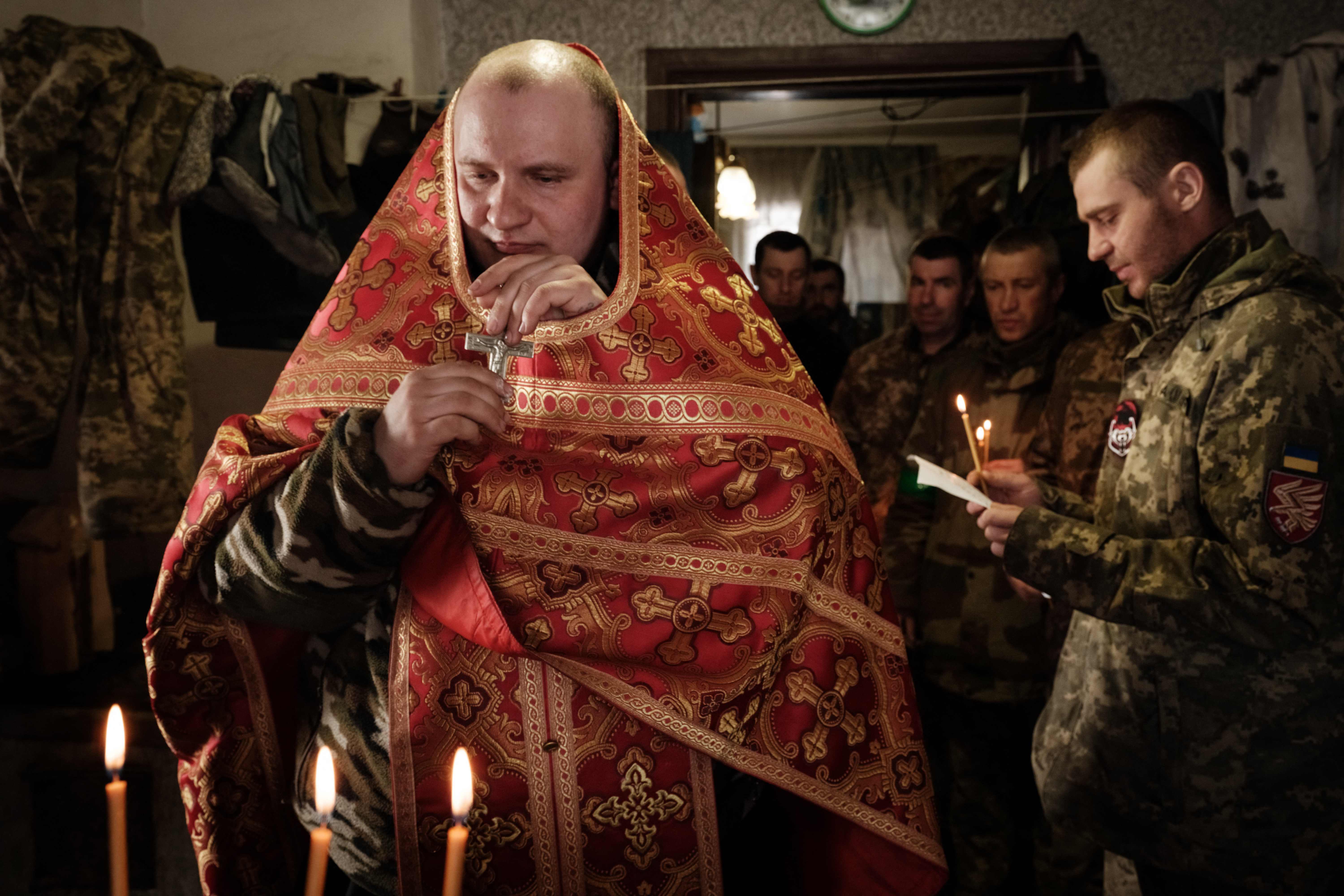 Mykola Berezyk (R), 28-year-old, chaplain to the Ukrainian Army?s 95th Air Assault Brigade, also known as “Father Mykola?, prepares to conduct a prayer for Ukrainian servicemen who returned from the frontline in the Donetsk region on February 22, 2023, amid the Russian invasion of Ukraine. (Photo by YASUYOSHI CHIBA / AFP)