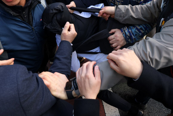 민주노총 경남지역본부 조합원이 23일 오전 경남 창원시 성산구 본부 입구에서 국정원 수사관에게 신분을 요청하고 있다.  해당 수사관은 기자회견이 진행되는 동안 촬영을 시도했고, 조합원에게 최초 ‘기자’라고 속였다가 뒤늦게 국정원 직원임이 확인됐다. 2023.2.23. 연합뉴스