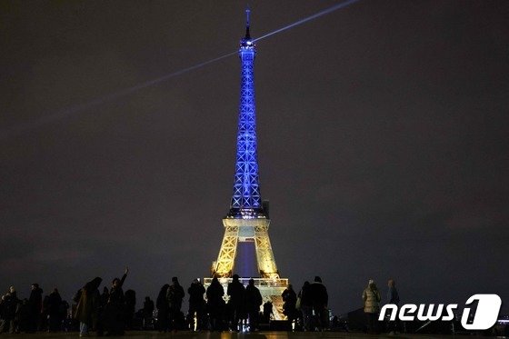 23일(현지시간) 프랑스 파리 에펠탑이 우크라이나 국기 색인 파랑과 노랑 빛깔로 빛나고 있다. 파리 AFP 뉴스1