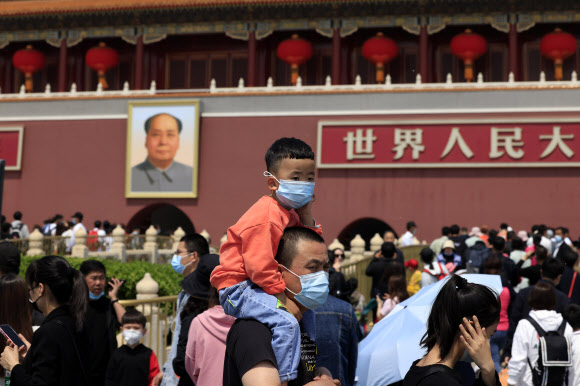 중국 베이징 톈안먼 광장에서 마스크를 쓴 한 남성이 아이를 목말을 태운 채 서 있다. 서울신문 DB