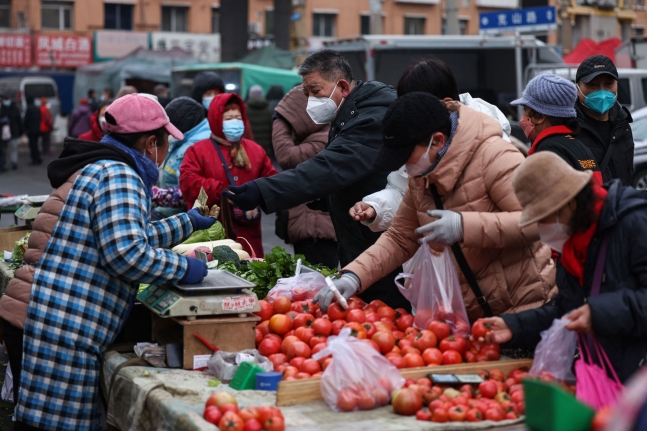 중국 랴오닝성 선양의 한 시장에서 시민들이 가판에서 과일과 채소를 사고 있다.  선양 AFP 연합뉴스