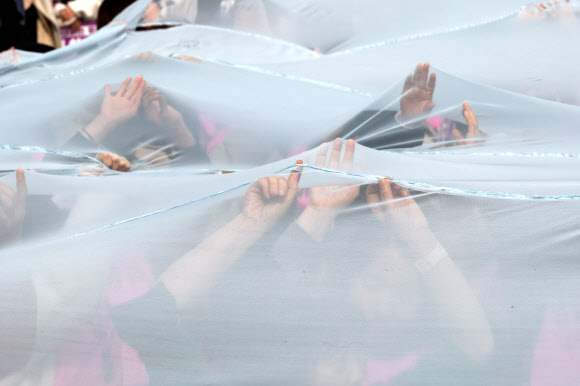 세계여성의날을 나흘 앞둔 4일 서울 종로구 보신각 앞에서 여성노동연대회의가 주최한 2023 여성노동자대회에서 참가자들이 여성차별의 상징인 유리천장을 깨고 나가자는 의미로 투명한 천을 찢는 퍼포먼스를 하고 있다. 2023.3.4 연합뉴스