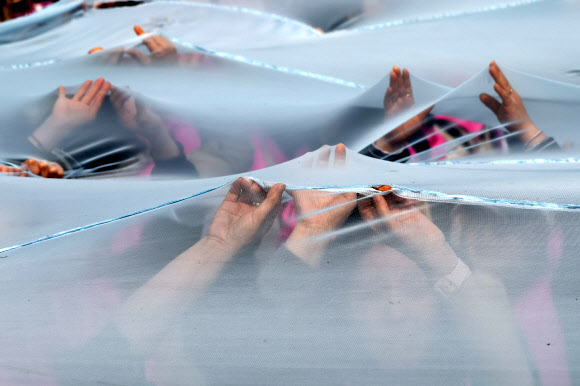 세계여성의날을 나흘 앞둔 4일 서울 종로구 보신각 앞에서 여성노동연대회의가 주최한 2023 여성노동자대회에서 참가자들이 여성차별의 상징인 유리천장을 깨고 나가자는 의미로 투명한 천을 찢는 퍼포먼스를 하고 있다. 2023.3.4 연합뉴스