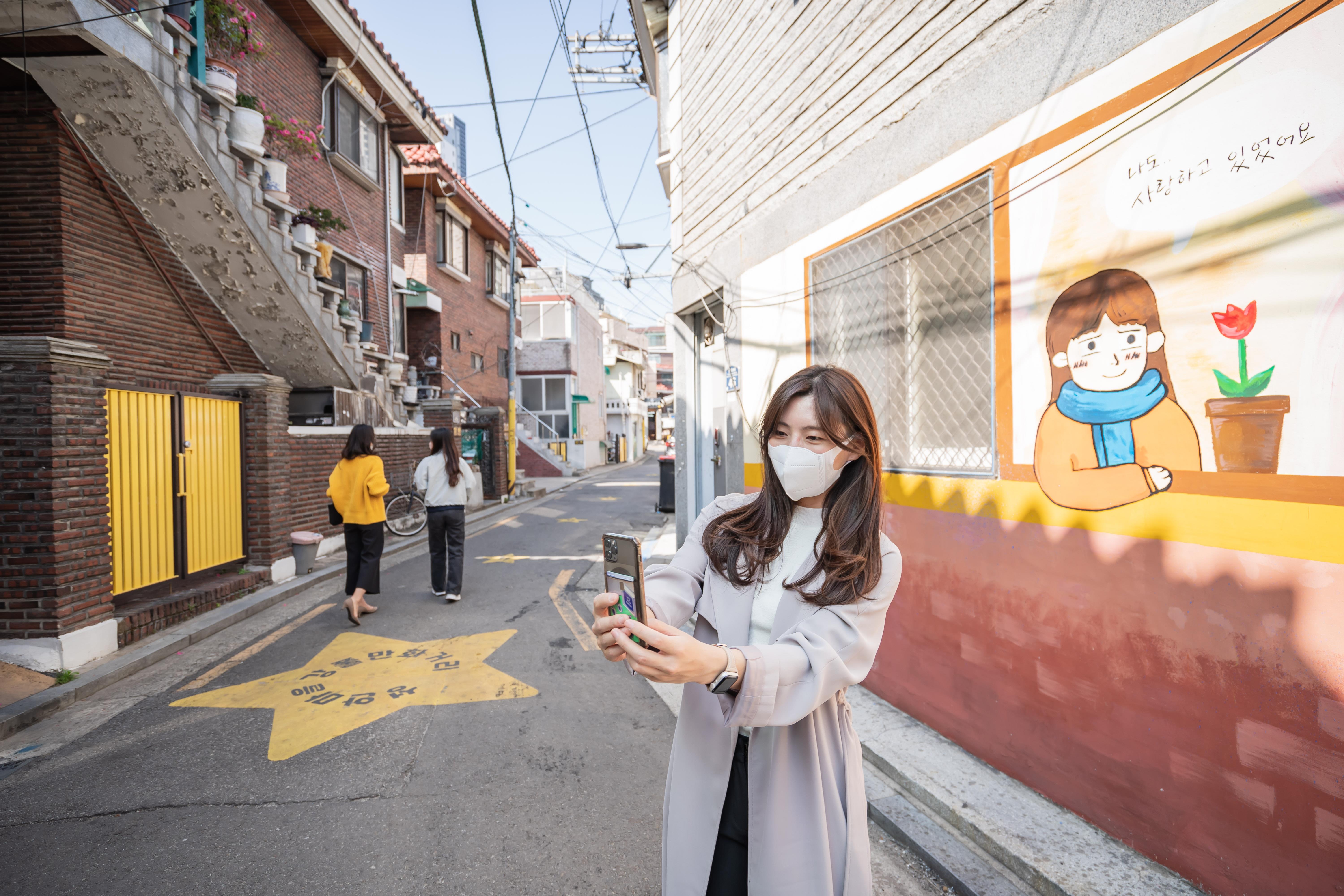 한 시민이 서울시 강동구 성내동 강풀만화거리에서 기념촬영을 하고 있다. 강동구 제공