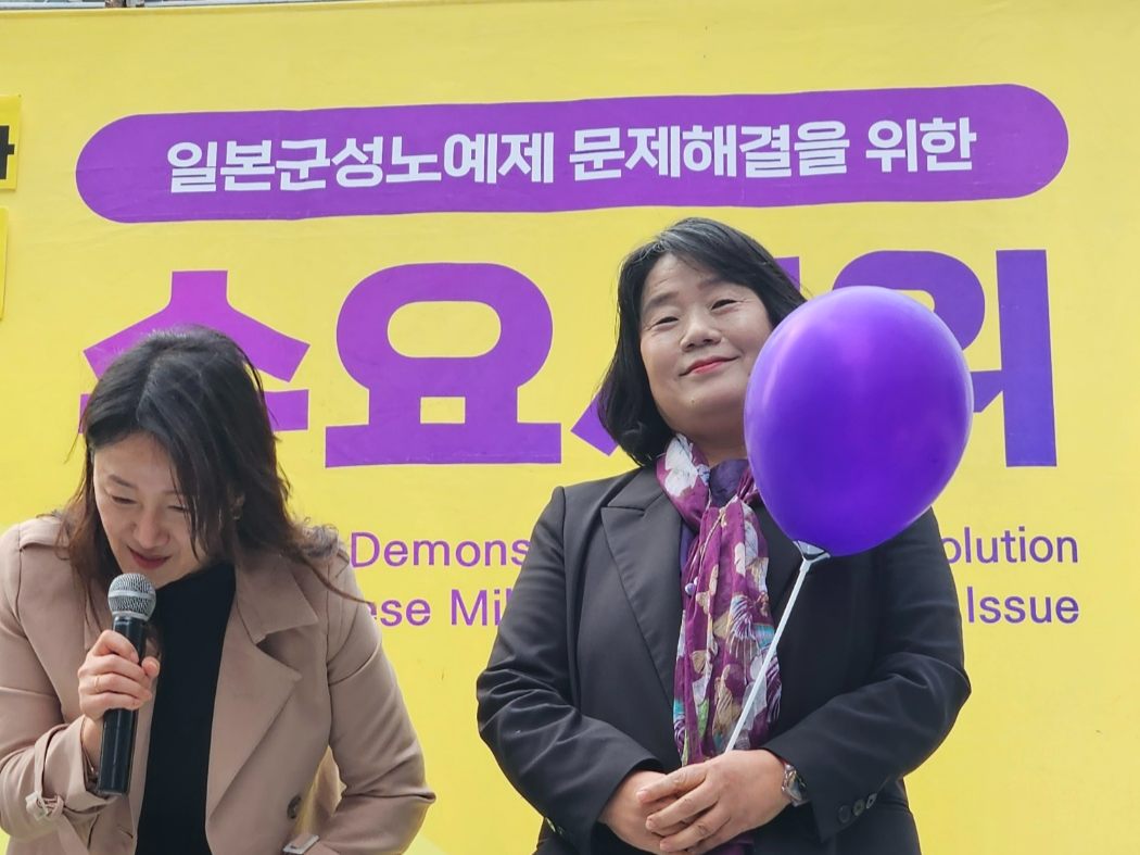 ‘세계 여성의 날’을 맞은 8일 서울 종로구 옛 일본대사관 앞 1586차 정기 수요시위에 참가한 윤미향(무소속) 의원이 여성의 날을 상징하는 보라색 풍선을 들고 발언대에 서 있다.