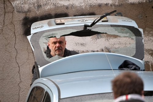 9일 우크라이나 수도 키이우 시민들이 러시아의 로켓 공격으로 파손된 차를 살펴보고 있다. 키이우 AFP 연합뉴스