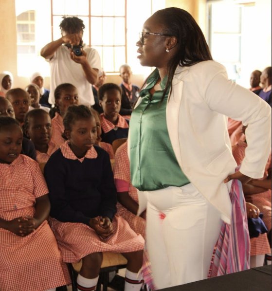 케냐의 글로리아 오워바 상원의원이 붉은 자국이 묻은 하얀색 바지 정장을 입고 나이로비 학교를 찾아 무료 생리대를 나눠주고 있다. 글로리아 오워바 트위터 캡처