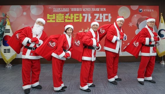 지난해 12월 24일 오전 서울 용산구 서울지방보훈청에서 열린 국 전몰 순직 군경 어린 자녀들을 위한 보훈 산타단 출범식에 박민식 국가보훈처장을 비롯한 히어로즈 패밀리 프로그램 후원. 지도단의 인요한 세브란스병원 국제진료센터 소장, 성우 안지환 씨, 가수 현숙(사진 왼쪽 두번째) 씨 등 멘토단이 산타복장을 하고 기념촬영을 하고 있다. 2022.12.24  뉴스1