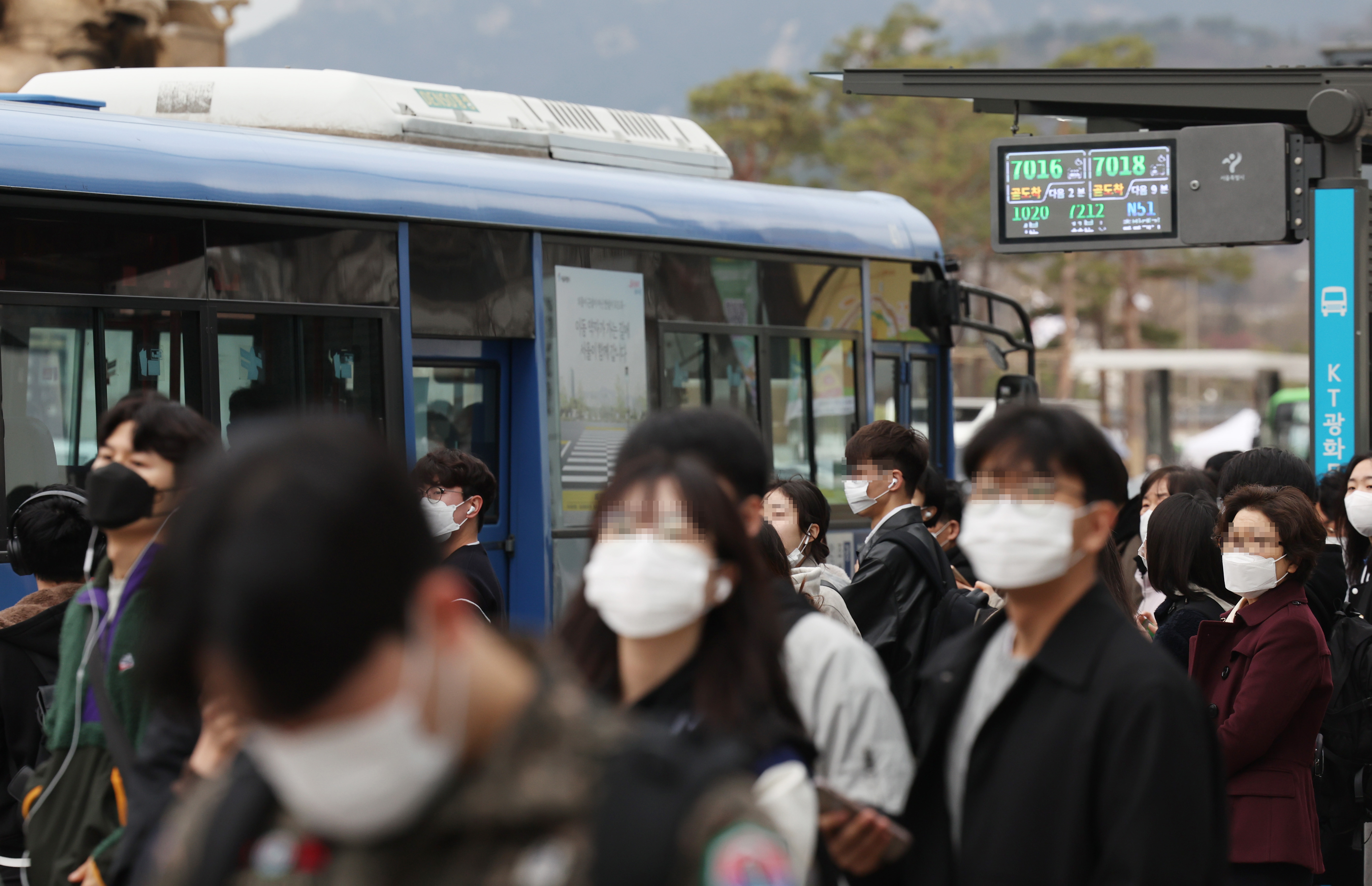 15일 오전 서울시내 한 버스정류장에서 마스크를 쓴 출근길 시민들이 버스를 기다리고 있다. 오는 20일부터 버스와 전철 등 대중교통에서도 실내 마스크 착용 의무가 해제되고 자율로 전환된다. 2023.3.15 연합뉴스
