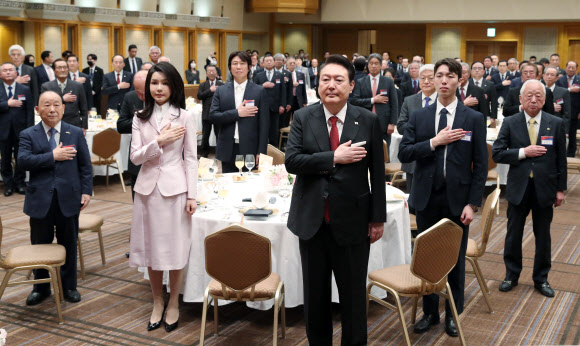 1박 2일간의 일정으로 일본을 방문한 윤석열 대통령과 김건희 여사가 16일 도쿄 한 호텔에서 열린 재일동포 오찬 간담회에서 국기에 경례하고 있다. 2023.3.16 연합뉴스