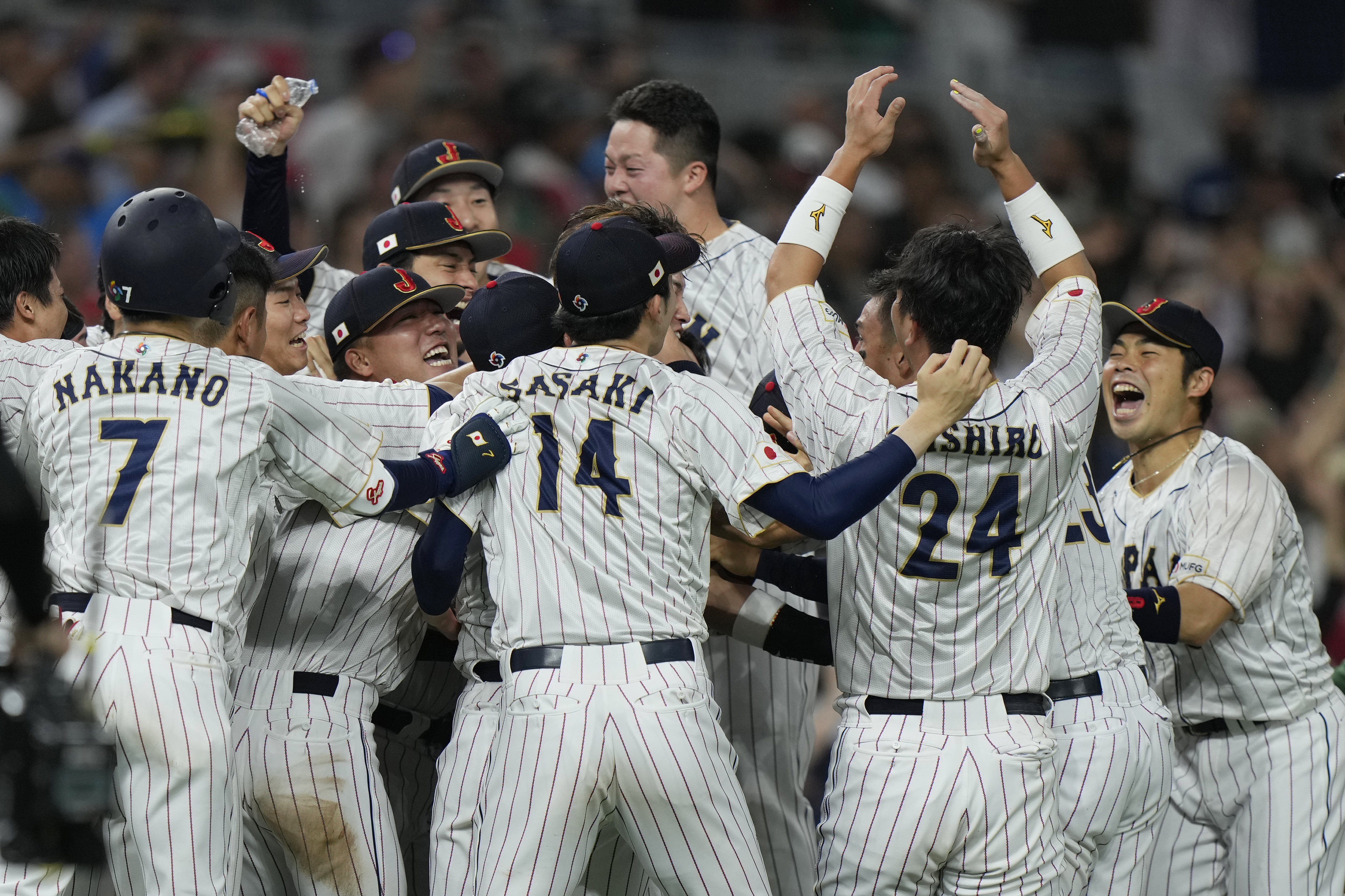 무라마키 무네타카의 끝내기 2루타로 역전 드라마를 완성한 일본 야구대표팀 선수들이 부둥켜 안고 기뻐하며 환호하고 있다.