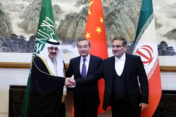 지난 10일 중국 베이징에서 무사드 빈 무함마드 알아이반(왼쪽부터) 사우디아라비아 국가안보보좌관과 왕이 중국 중앙정치국 위원, 알리 샴카니 이란 최고 국가안보위원회 위원장이 손을 맞잡고 있다. 2023.3.10 로이터 연합뉴스