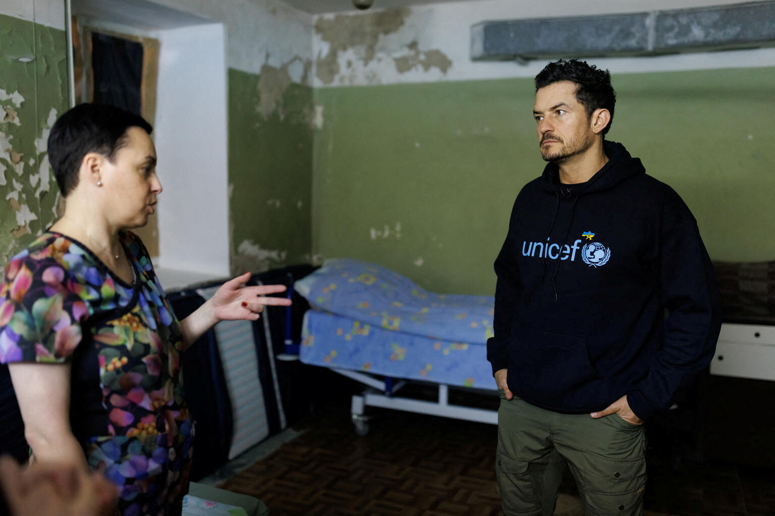 유엔아동기금(UNICEF·유니세프) 친선대사인 영국 배우 올랜도 블룸이 25일(현지시간) 우크라이나 수도 키이우의 한 산부인과 병원 지하 방공호에서 현지 산부인과 전문의 올레나와 이야기를 나누고 있다. 2023.3.27 로이터 연합뉴스