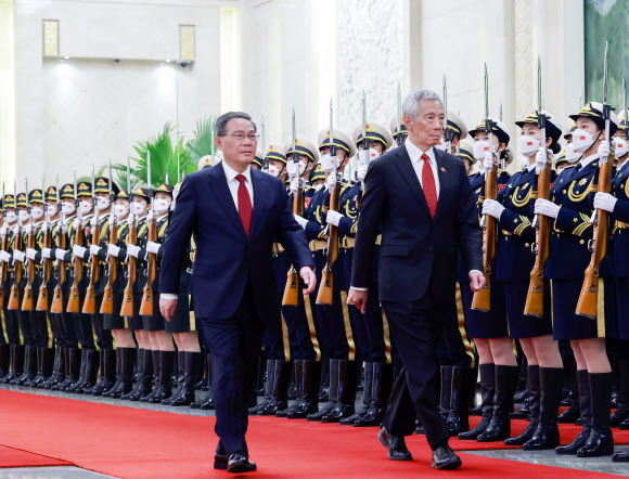 리셴룽(오른쪽) 싱가포르 총리가 지난 1일 중국 베이징 인민대회당에서 열린 환영 행사에서 리창 중국 국무원 총리의 안내를 받아 회담장으로 향하고 있다. 베이징 신화 연합뉴스