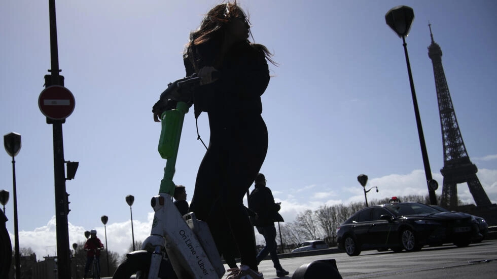 한 여성이 31일 에펠탑을 배경으로 전기 스쿠터를 타고 있다. 파리 AP