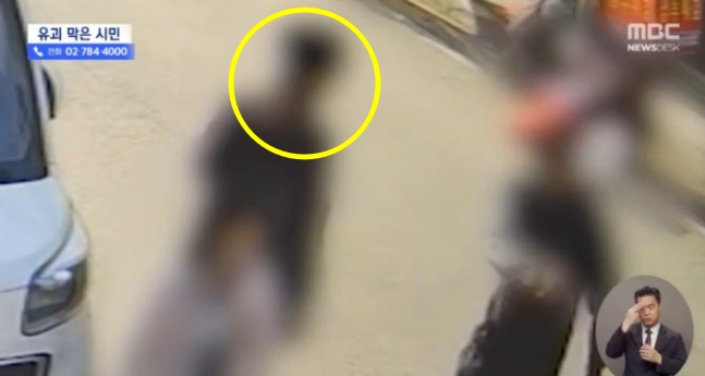 9살 여아를 데려가려던 남성이 이웃시민(노란색표시)에게 제지 당하고 있다. MBC 뉴스 캡처