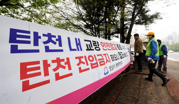 6일 오전 보행로 일부 구간 침하 현상이 확인돼 통제 중인 경기도 성남시 불정교 주변에 성남시 관계자들이 진입 금지 현수막을 설치하고 있다. 전날 경기 성남시 분당구 정자동 정자교에서는 보행로가 붕괴해 2명의 사상자가 발생했다. 2023.4.6 연합뉴스