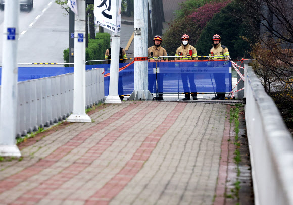 6일 오전 보행로 일부 구간 침하 현상이 확인돼 통제 중인 경기도 성남시 불정교에서 소방 관계자들이 다리를 살펴보고 있다. 전날 경기 성남시 분당구 정자동 정자교에서는 보행로가 붕괴해 2명의 사상자가 발생했다. 2023.4.6 연합뉴스
