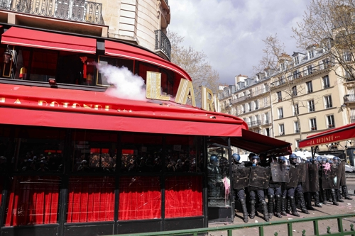 프랑스 연금개혁 반대 시위대가 6일 파리의 에마뉘엘 마크롱 대통령 단골 식당에 불을 지르고 있다. 파리  AFP 연합뉴스