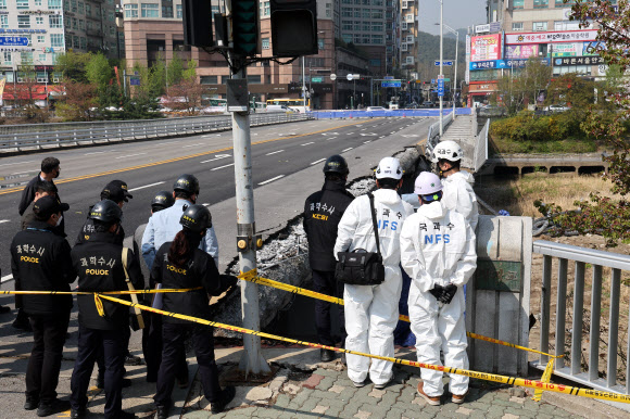 보행로가 무너지며 두 명의 사상자가 발생한 경기 성남시 분당구 정자교에서 7일 오전 경찰과 국과수 등 관계자들이 사고 원인을 찾기 위한 합동감식을 하고 있다. 연합뉴스.