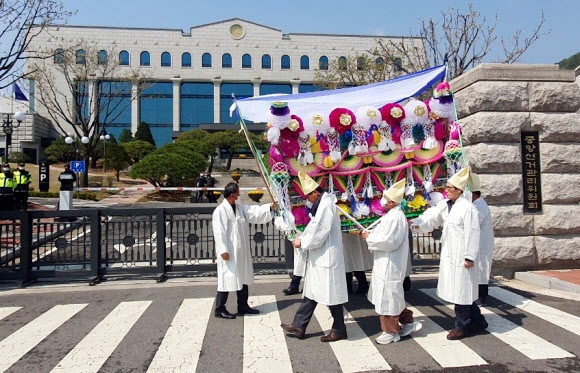 전북 순창군 구림농협 트럭 사고로 가족을 잃은 주민들이 7일 경기 과천시 중앙선거관리위원회 앞에서 상여를 짊어지고 선관위의 투표소 관리 책임을 따지고 있다. 순창 구림농협 사고는 제3회 전국동시조합장선거가 치러진 지난달 8일 오전 10시 30분께 운전자 A(74)씨가 조합장 투표를 기다리던 인파 수십 명을 트럭으로 들이받아 발생했다. 이 사고로 4명이 숨졌고 16명은 중·경상을 입었다. 2023.4.7. 유족 협의회 제공