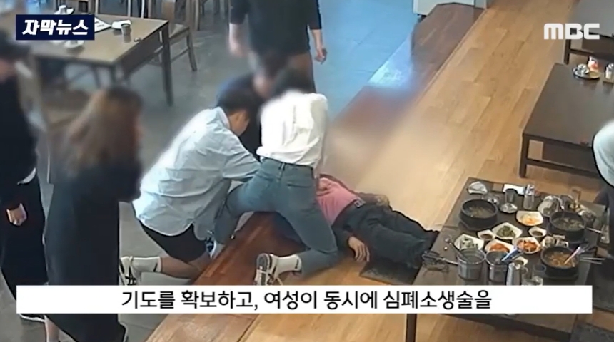 20대 남녀가 쓰러진 남성에게 심패소생술을 하고 있다. MBC 보도화면 캡처