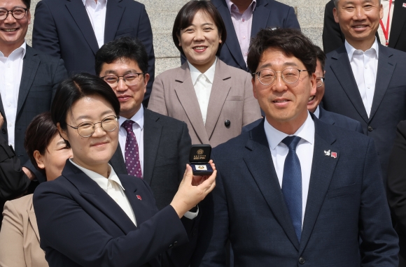 윤희숙(앞줄 왼쪽) 진보당 상임대표가 10일 오전 국회 본청 앞 계단에서 열린 강성희(앞줄 오른쪽) 의원 등원 기자회견에서 전주시민을 대표해서 강성희 의원에게 의원 배지를 달아주는 퍼포먼스를 하고 있다. 연합뉴스