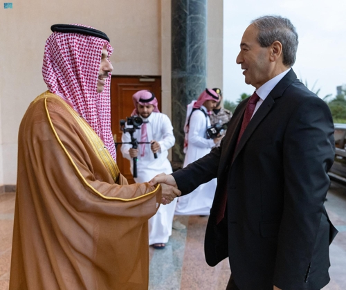 파이살 빈 파르한 알사우드(왼쪽) 사우디아라비아 외교장관이 12일 사우디 제다에서 파이잘 메크다드 시리아 외무장관과 만나 외교관계 회복에 합의하고 있다.  제다 로이터 연합뉴스