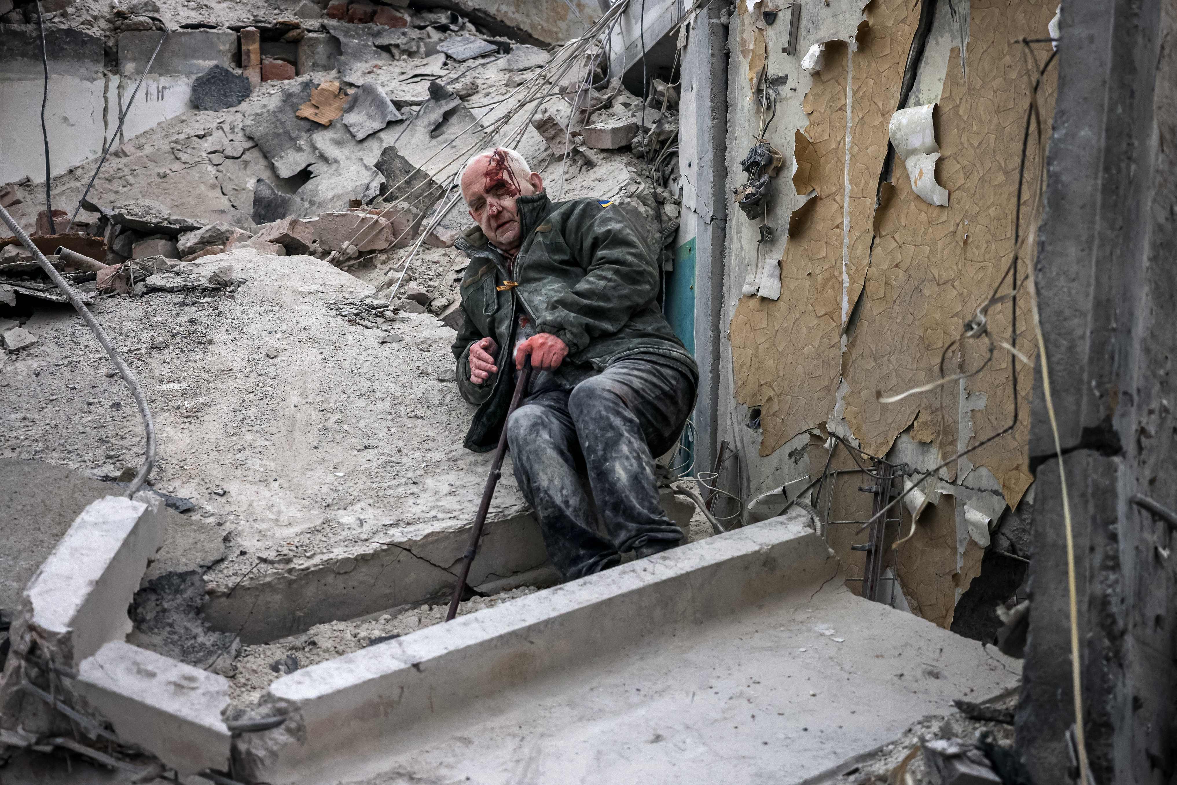 14일(현지시간) 우크라이나 도네츠크주 슬로뱐스크에서 러시아군 미사일 공격으로 파괴된 아파트 잔해 밑에 깔렸다가 구조된 노인이 피를 흘리며 앉아 있다. 2023.4.15 AFP 연합뉴스